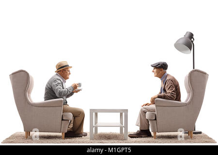 Two elderly men seated in armchairs having a conversation isolated on white background Stock Photo