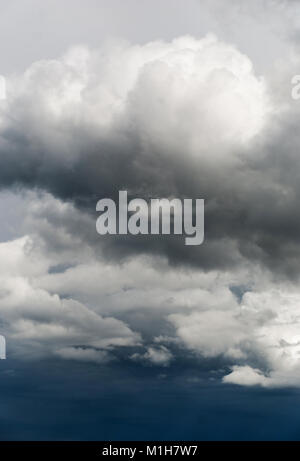 Gray and white storm clouds on hte dark blue sky Stock Photo