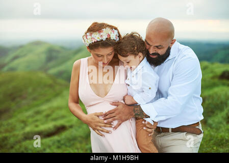 Pregnant woman with family put hand on belly Stock Photo