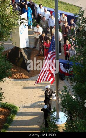 Aerial photograph of CDC (Centers for Disease Control) employees gathered outside for a September 11th remembrance ceremony, with two uniformed officers from the United States Public Health Service lowering the flag to half-staff, CDC sign visible in foreground, Atlanta, Georgia, 2003. Image courtesy CDC. () Stock Photo