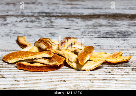 dry orange peel just for use in an aromatic beverage on an old wooden white table Stock Photo