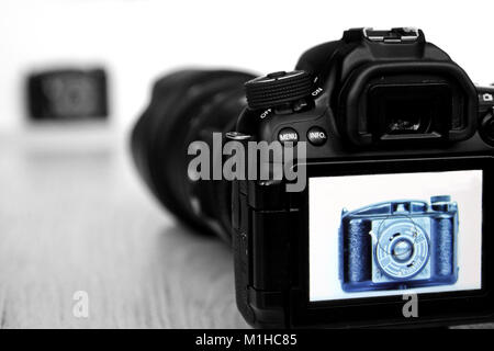 A picture of an old manual camera seen through the new and modern one. It shows the contrast between the old and new camera and photography style. Stock Photo