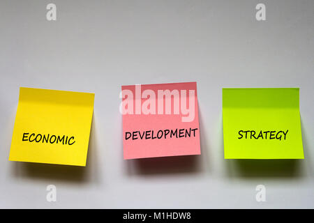 "Economic development strategy", the phrase is written on multi-colored stickers on white background. Stock Photo