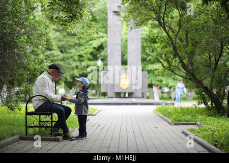 Grandpa is walking with her grandson in a spring park. Grandson  Stock Photo