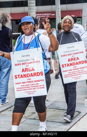 Miami Florida,protest demonstration labor signs posters,unfair wages picket line,Black female women carpenters union,protesting construction company Stock Photo