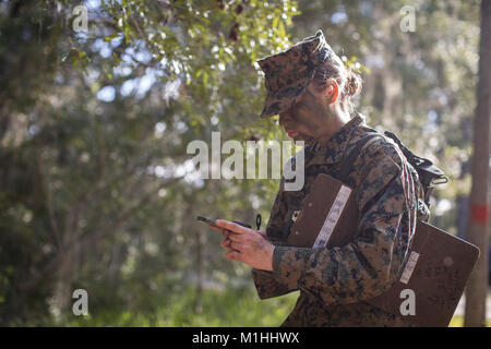 U.S. Marine Corps Rct. Kaylynn K. Kalama with Platoon 4001, Oscar Company, 4th Recruit Training Battalion, prepares to enter the land navigation course Dec. 14, 2017, on Parris Island, S.C. Recruits, like Kalama, 18, from Hamilton, Ohio, learn how to traverse unfamiliar territory using a map and compass during Basic Warrior Training. Oscar Company graduated Jan. 5, 2018. Parris Island has been the site of Marine Corps recruit training since Nov. 1, 1915. Today, approximately 19,000 recruits come to Parris Island annually for the chance to become United States Marines by enduring 12 weeks of ri Stock Photo