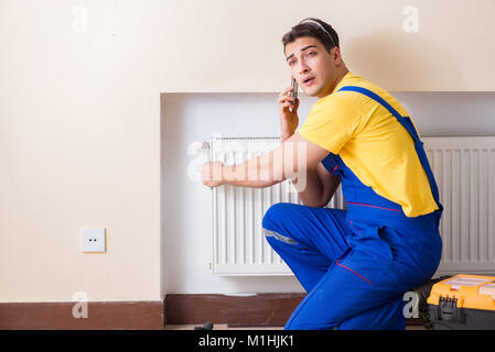 Young repairman contractor repairing heating panel Stock Photo