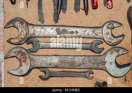 old spanners placed on a wooden wall Stock Photo