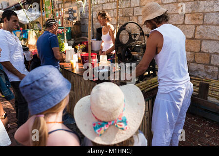 Man pressing sugar cane at a mojito bar at the Fira d'Indians in Begur, Spain Stock Photo