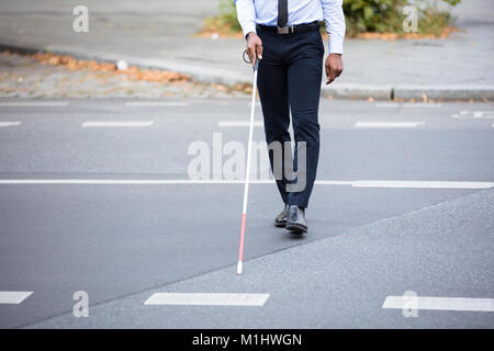 Blind Person With White Stick Walking On Street Stock Photo