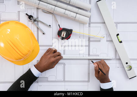 High Angle View Of Architect Hands Working On Blueprint Stock Photo