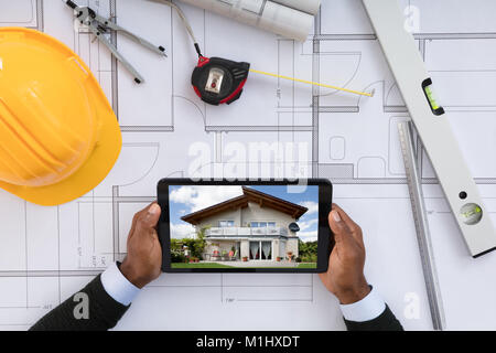 Male Architect Looking At Digital Tablet Over Blueprint Stock Photo