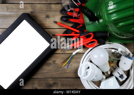 Black laptop with work tools and electrical equipment on an antique wooden desk. Stock Photo