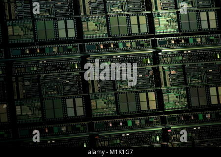 A close up shot showing multiple integrated circuit chips on a manufacturing wafer before they are cut to individual packages. Stock Photo