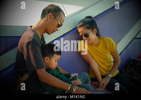 Thai family of three on a boat in Phuket, Thailand. 19-Jan-2018 Stock Photo