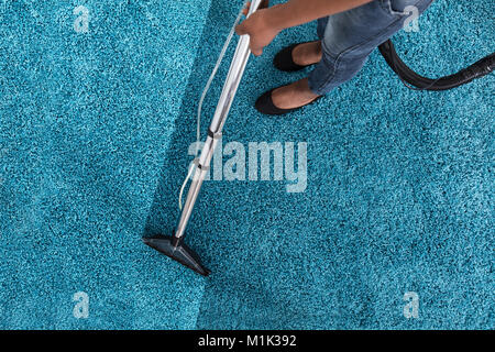 Person Using Vacuum Cleaner For Cleaning Blue Carpet At Home Stock ...