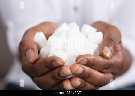 Elevated View Of A Human Hand Holding Sugar Cubes Stock Photo