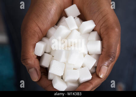 Elevated View Of A Human Hand Holding Sugar Cubes Stock Photo