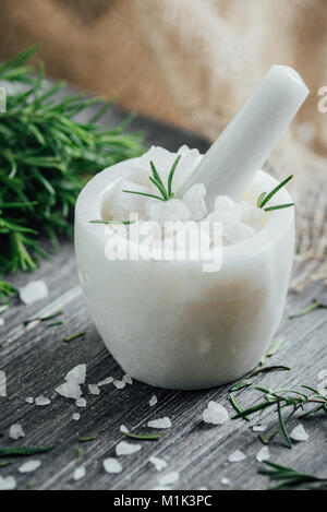 Marble indian mortar for spices, salt, olive oil and sprigs of rosemary on a wooden cutting board Stock Photo