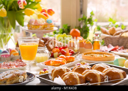Breakfast or brunch table filled with all sorts of delicious delicatessen ready for an Easter meal. Stock Photo