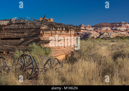 Kirk's Cabin, built as a seasonal shelter by a rancher, with adzed logs and a wagon parked outside, in Salt Creek Canyon in The Needles District of Ca Stock Photo