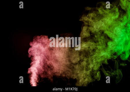 Thick colorful smoke of green, red, yellow on a black isolated background. Background from the smoke of vape Stock Photo