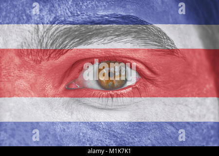 Human face and eye painted with flag of Costa Rica Stock Photo