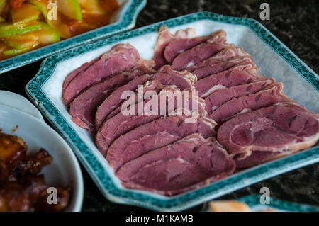 Home cooked Chinese food in the rural area of Xi’an, Shaanxi Province, China. Main dish boiled beef slices with a dish of hongshaorou (braised pork) a Stock Photo