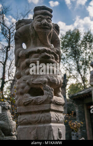 A post statue of a bearded old man riding a lion like creature. Part of Wu Jianguo’s antique collection located in the rural part of Xi’an. Stock Photo