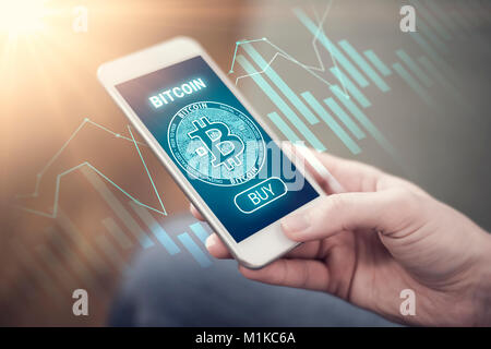 Bitcoin symbol on mobile app screen with big BUY button and growth chart in the background. Bitcoin grow concept. New digital money. Stock Photo