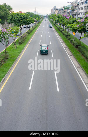 Cars driving on the asphalt highway lined by traffic island trees, Huanhe Expressway, Wanhua District, Taipei City, Taiwan Stock Photo