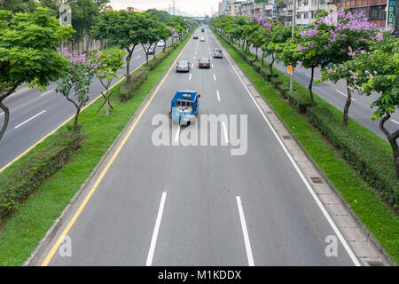 Cars driving on the asphalt highway lined by traffic island trees, Huanhe Expressway, Wanhua District, Taipei City, Taiwan Stock Photo