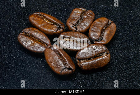 Roasted coffee beans on black background. Stock Photo
