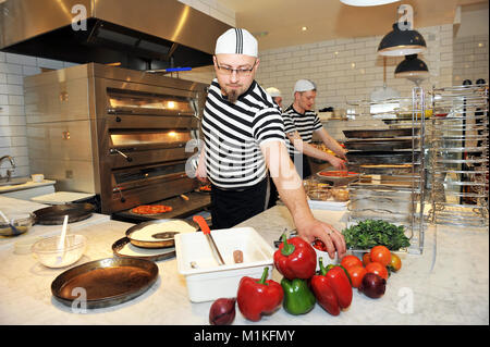 A waiter prepares food in a pizza restaurant UK Stock Photo