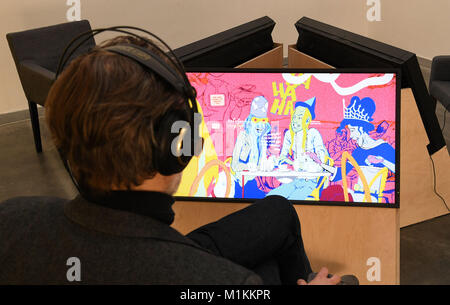 Oldenburg, Germany. 30th Jan, 2018. An employee of the Edith Russ house for media art sitting in front of the mixed media installation 'The Solar Girl' by Ganzeer in Oldenburg, Germany, 30 January 2018. Comics in art, so-called graphic nivels, are mirrors of society. History and trends of the current art form are the subject of the three Oldenburg museums, the Edith Russ house für media art, the Horst Janssen museum und the city museum. (ATTENTION EDITORS: FOR EDITORIAL USE ONLY IN CONNECTION WITH CURRENT REPORTING; MANDATORY CREDIT) Credit: Carmen Jaspersen/dpa/Alamy Live News Stock Photo