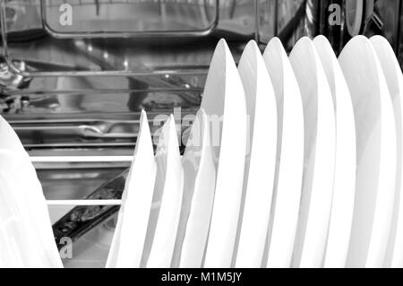 basket loaded with freshly washed dishes inside the dishwasher Stock Photo