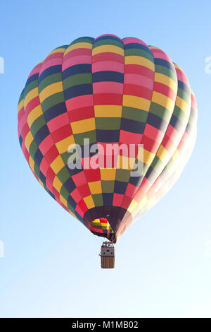 Hot air balloons in flight with vibrant colours against early morning blue sky Stock Photo