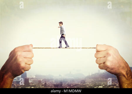 man hovering on a rope held by two hands Stock Photo