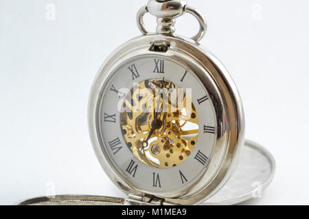 isolated vintage pocket watch with exposed gears, see through body and spring powered Stock Photo