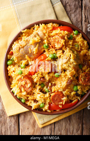 Arroz Valenciana with rabbit, chorizo, vegetables and spices in a bowl on the table. vertical top view from above Stock Photo