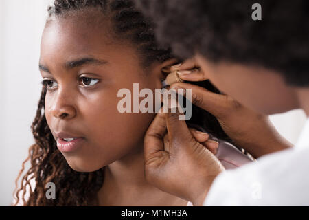 Close-up Of A Doctor Putting Hearing Aid In Patient's Ear Stock Photo