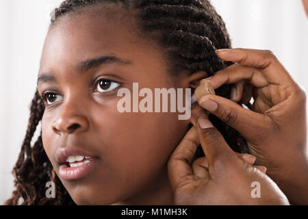 Close-up Of A Doctor Putting Hearing Aid In Patient's Ear Stock Photo