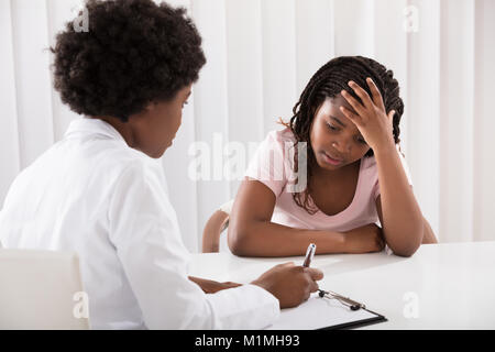 Portrait Of Female Doctor Comforting Depressed Patient Stock Photo