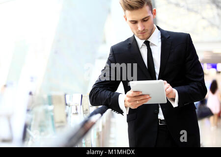 Businessman Using Digital Tablet In Airport Departure Lounge Stock Photo