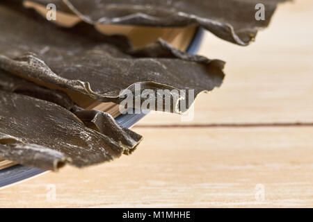 Dried kombu seaweed (Laminariaceae longissima) in a plate. Copy space Stock Photo