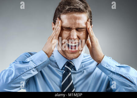 Businessman with pain in his temples. Photo of man suffering from stress or a headache grimacing in pain. Medical concept Stock Photo