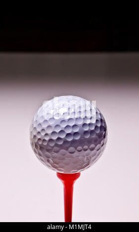White golf ball on red tee peg Stock Photo