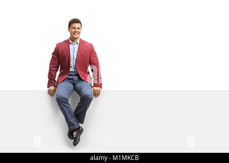 Elegant guy seated on a panel looking at the camera and smiling isolated on white background Stock Photo