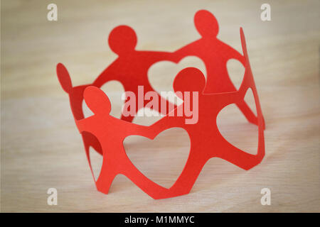 Paper people in a circle holding hands - Teamwork and love concept Stock Photo