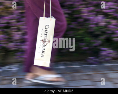 Speed Blur Female Wine Buyer with bottle bag containing Château Julien wine bottle purchased from the Estate in Carmel Valley, California USA. Stock Photo